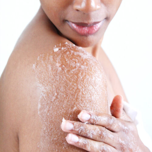 Woman exfoliating skin with salt scrub. Earthsavers Osea Undaria Body Contour Treatment