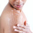 Woman exfoliating skin with salt scrub. Earthsavers Osea Undaria Body Contour Treatment